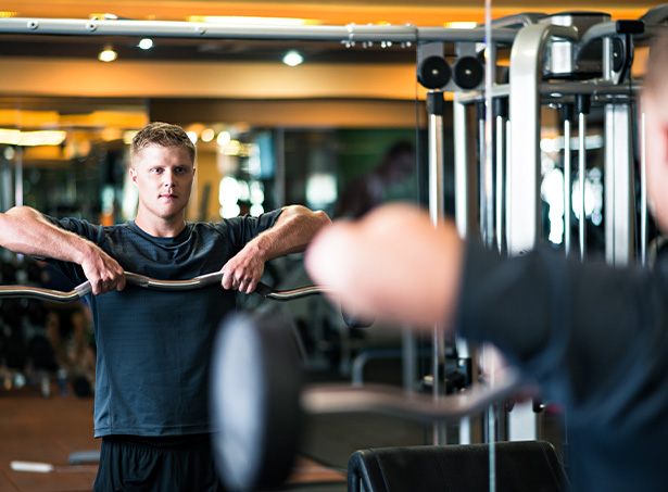 man working out in gym focusing on barbell exercise strength training fitness three